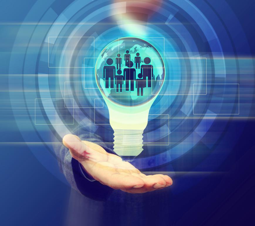 A hand holding a glowing lightbulb that contains a globe and icons of people, symbolizing a connected global community or network.