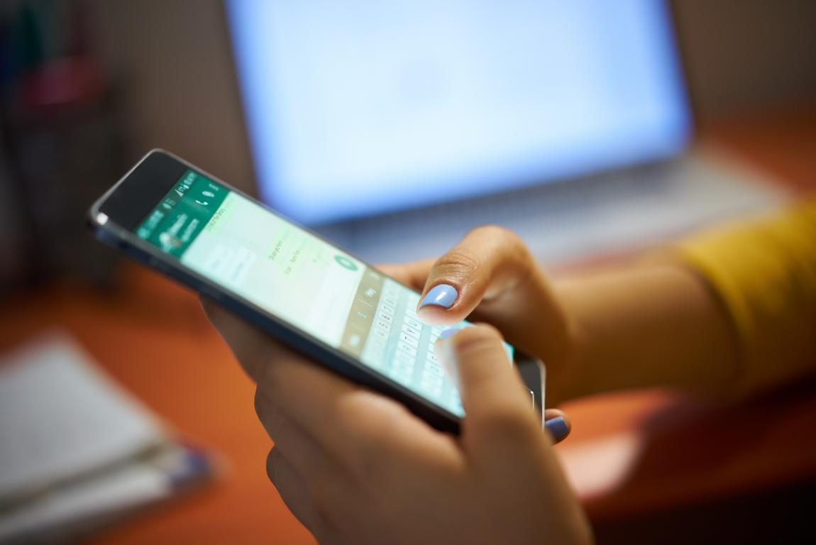  A person's hands holding a smartphone and typing a message in WhatsApp, demonstrating direct mobile communication.
