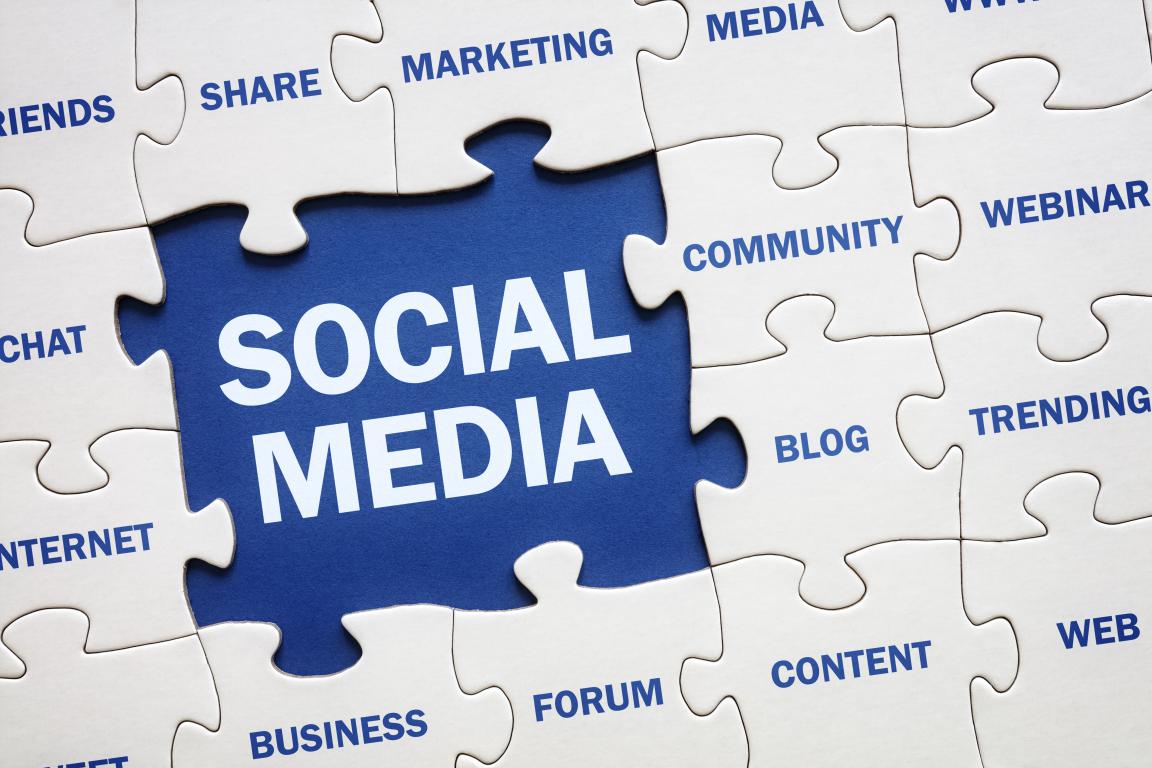 A jigsaw puzzle coming together with a central blue piece that says "SOCIAL MEDIA" surrounded by related marketing terms.