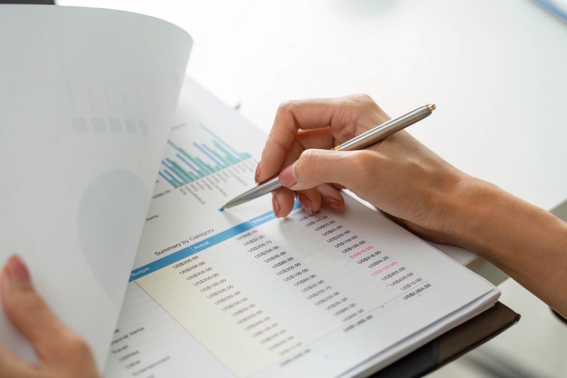 A person's hand holds a pen, pointing at a Workplace Safety Plan