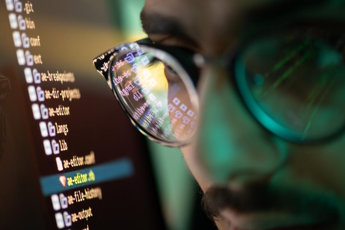 A close-up of a data processor's glasses reflecting computer code, symbolizing the responsibility of handling personal data securely under GDPR.