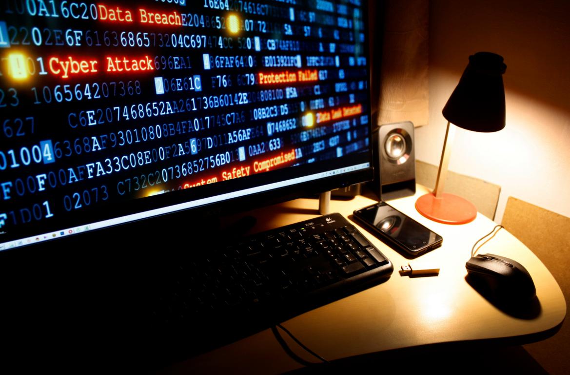 A computer monitor displaying code and red text warnings for "Data Breach" and "Cyber Attack," representing a security incident under GDPR.