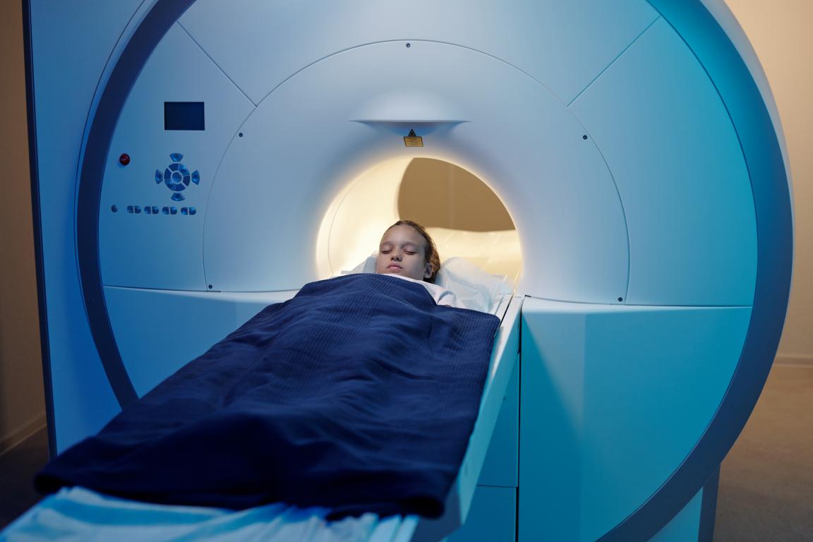 A young patient lies peacefully inside an MRI scanner, illustrating the importance of staying still during the imaging process.