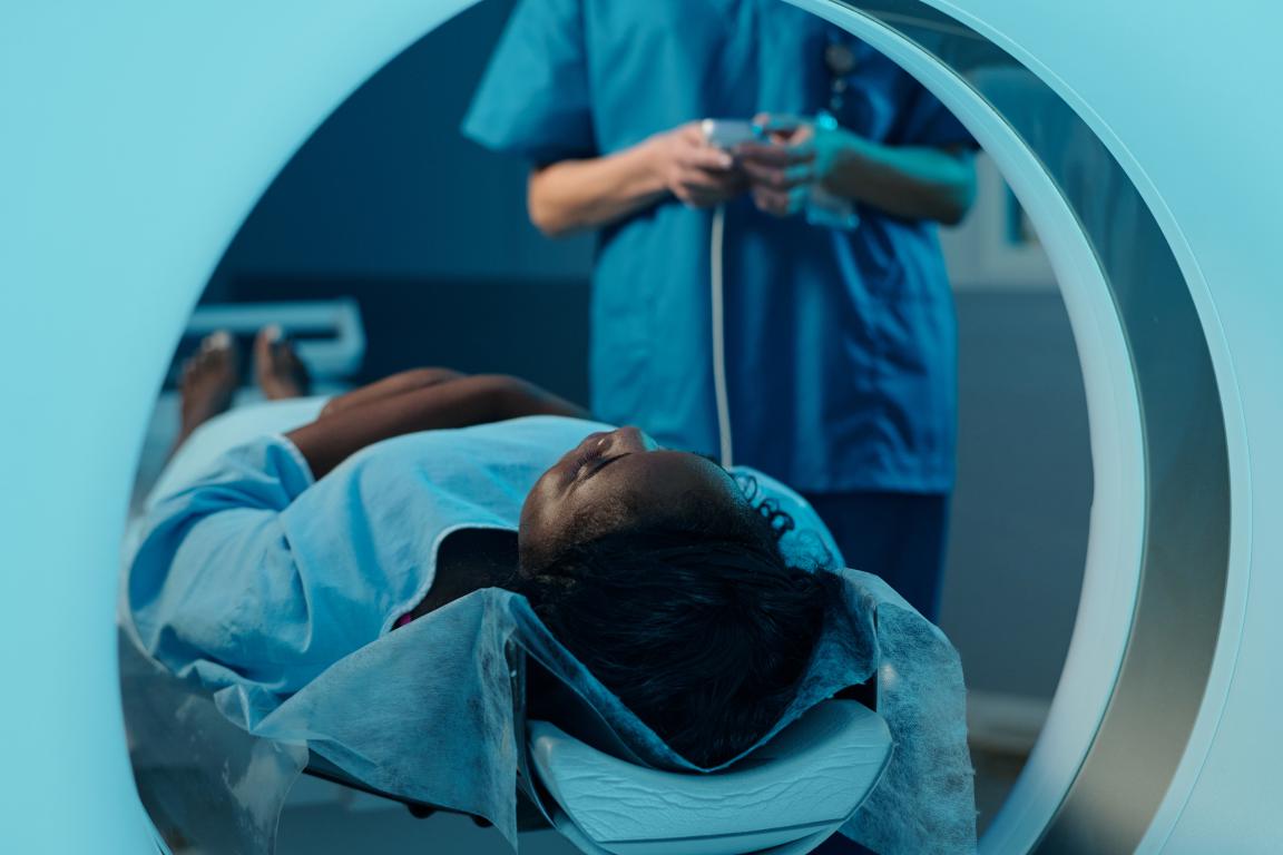 A view from within the MRI scanner as a patient lies still, with the radiographer nearby to ensure their comfort and safety throughout the scan.