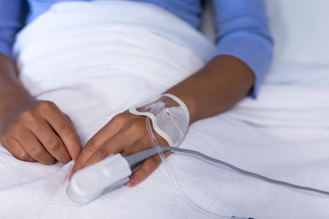 A close-up of a hand with a pulse oximeter on the finger, a device used in sleep studies to measure blood oxygen levels, crucial for calculating AHI.