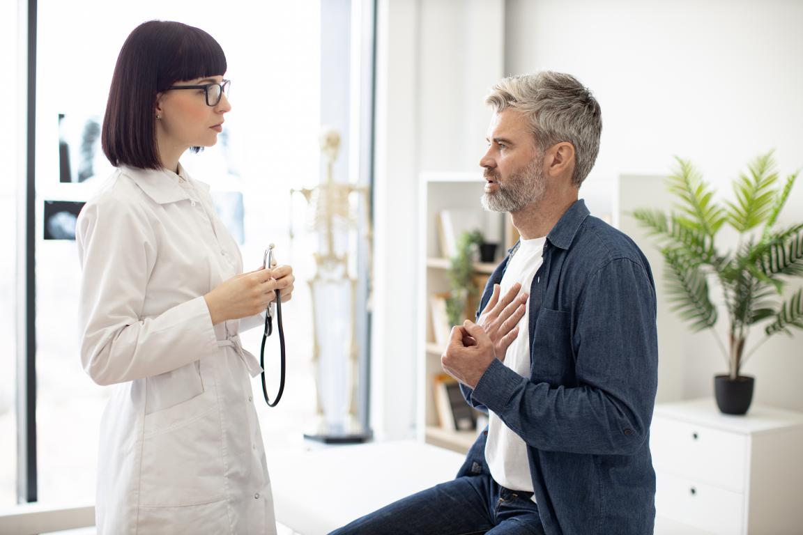 A doctor carefully listens as a male patient describes any discomfort after his ICD procedure.