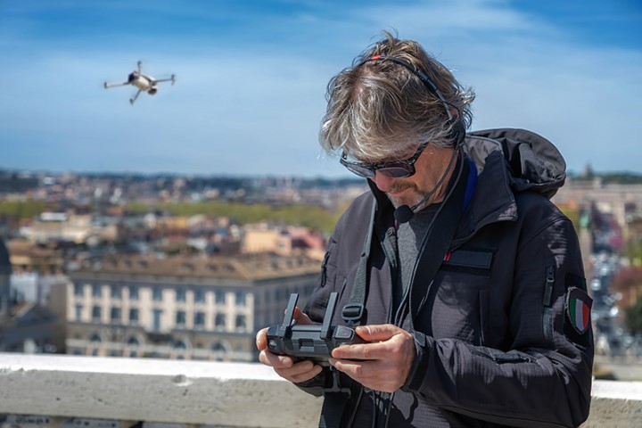 man flying a drone in a city
