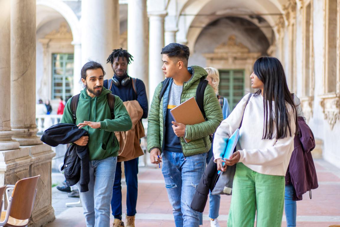 Students walking through a university building entrance or hallway, illustrating the need for ID access.
