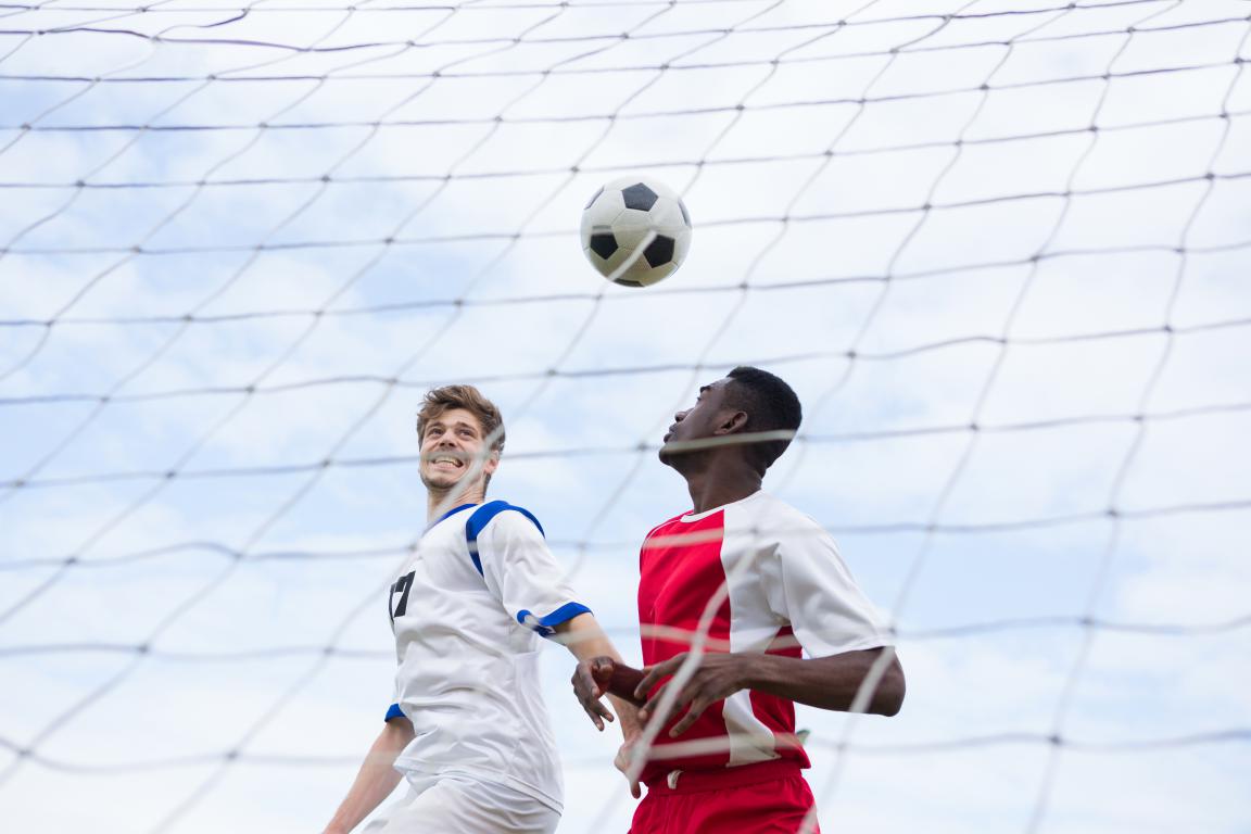 Football players heading the ball during a club match