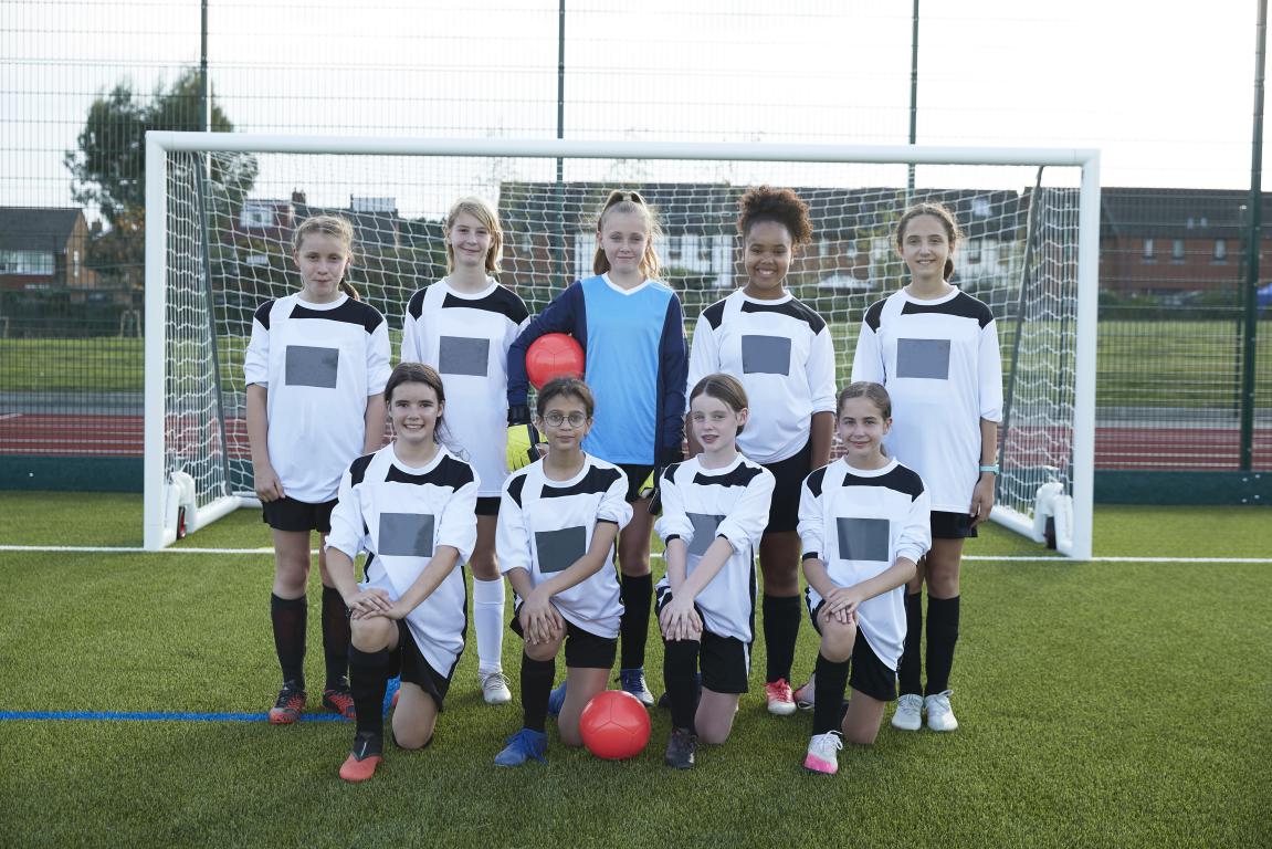 Girls’ youth team lining up on the pitch before kick-off